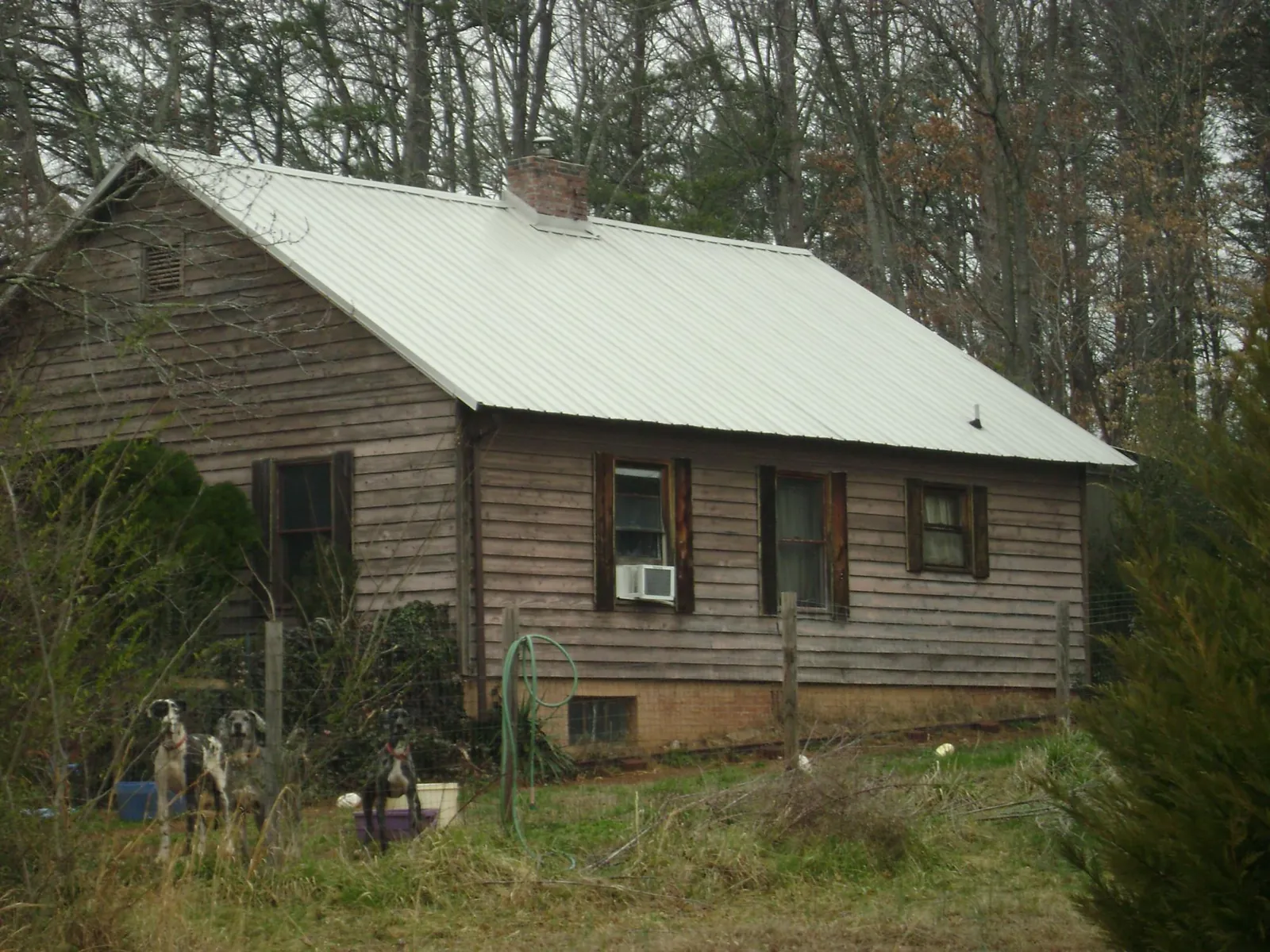 White metal roof on an old wood sided farmhouse, from a Metal Roof Installation job in Conetoe